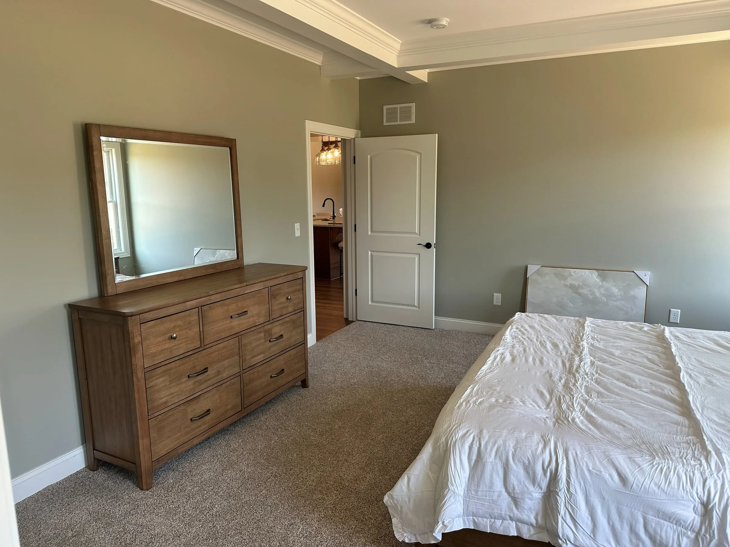 Model home bedroom with a dresser and mirror