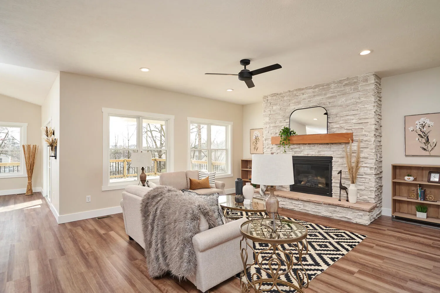 Furnished great room with a stone fireplace in the Willow Run model home