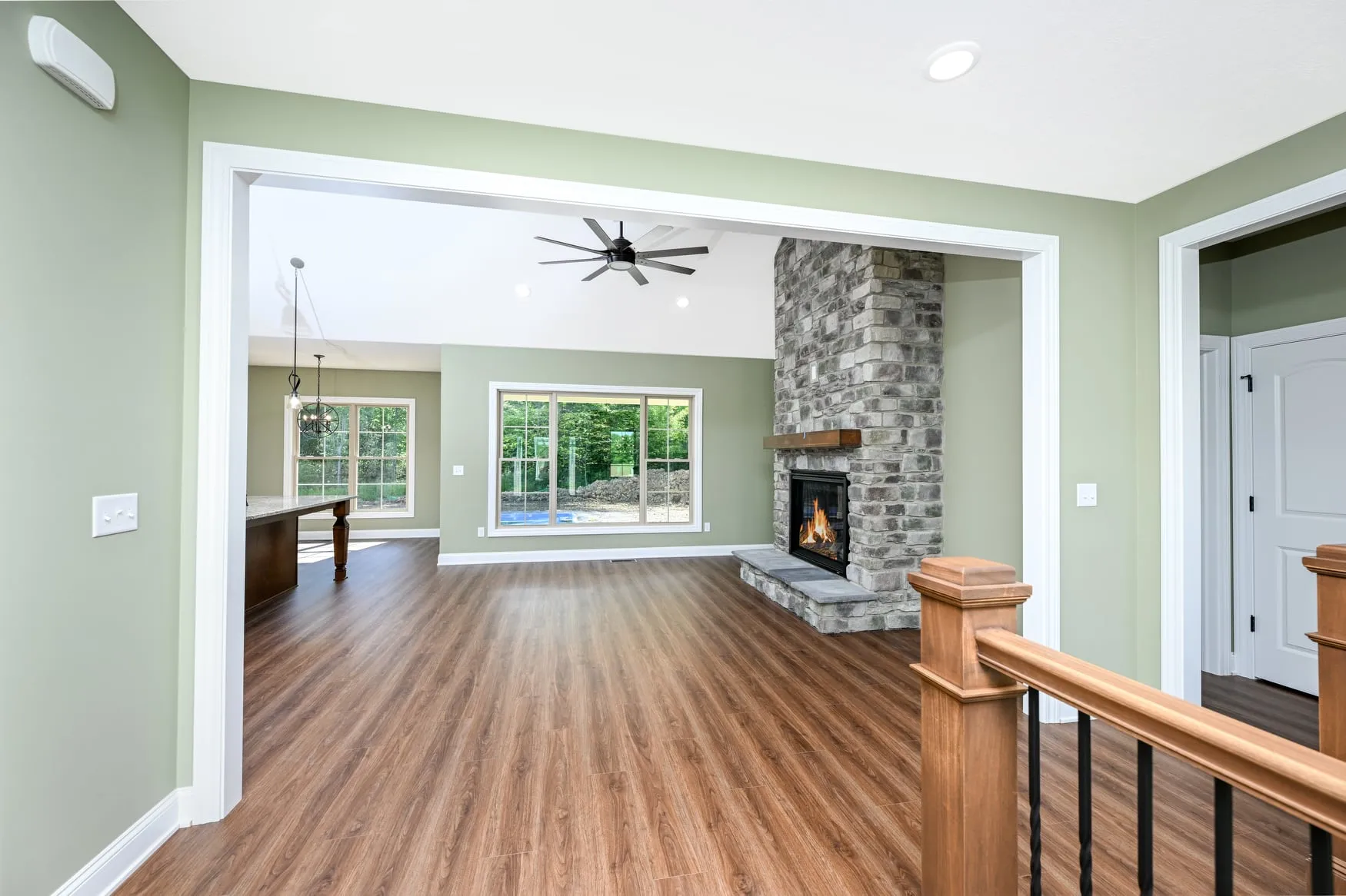 Great room with a stone fireplace and wide-plank flooring