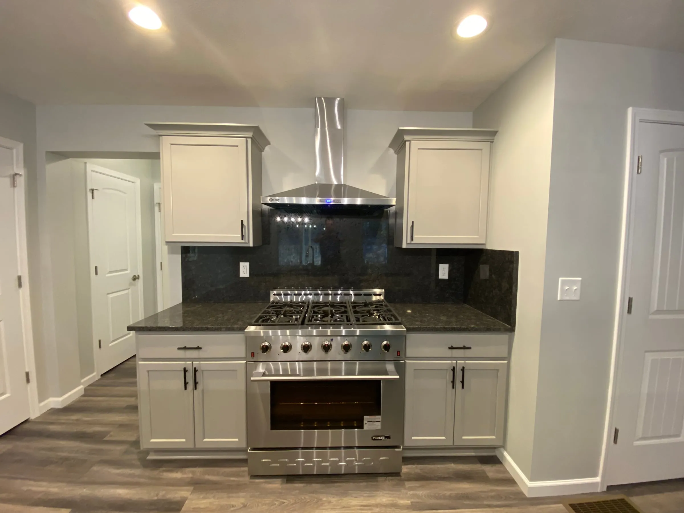 Kitchen with white cabinets and a professional range