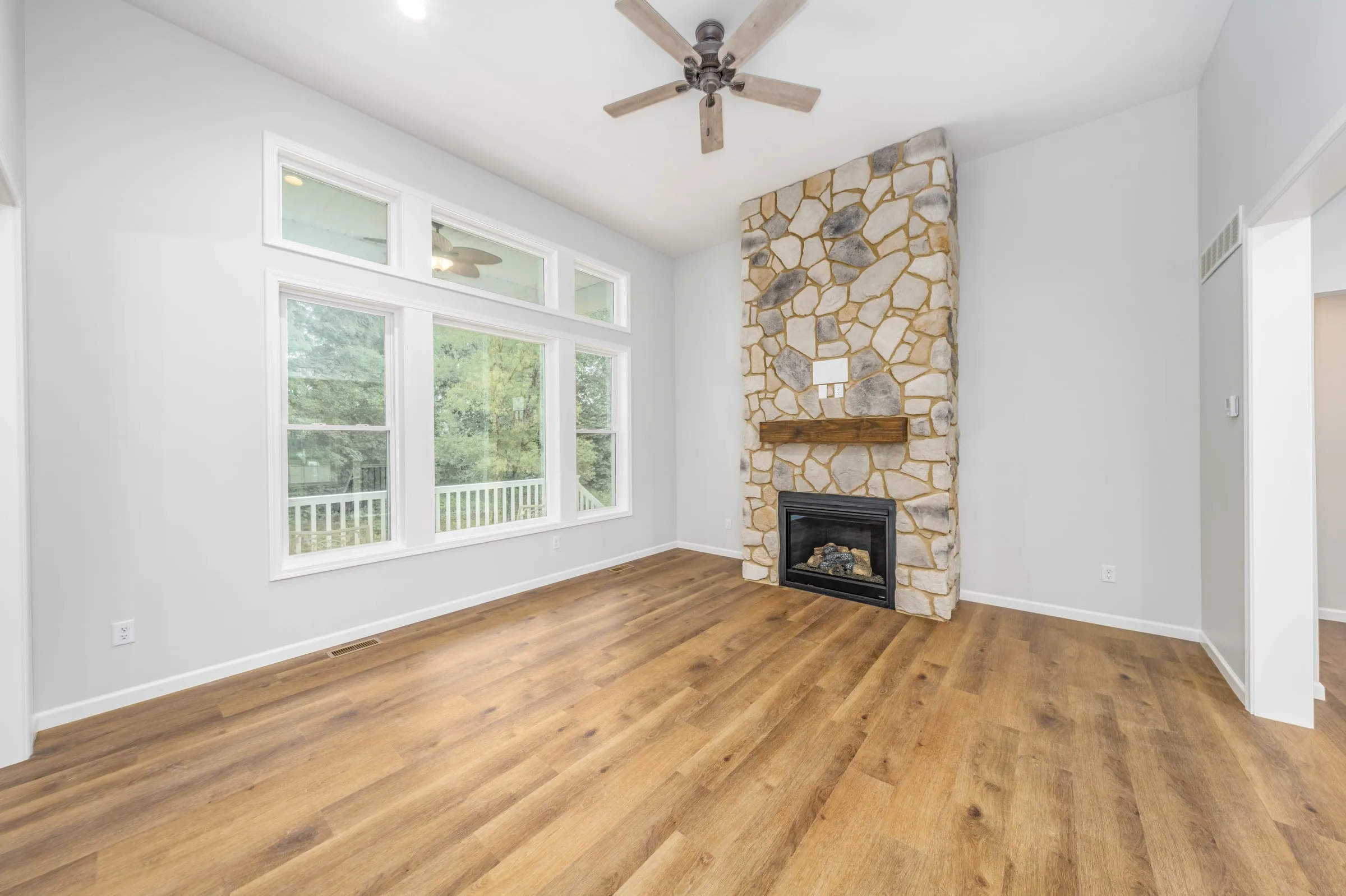 Great room with stone fireplace and large windows